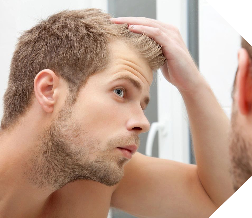 A man looking at his hair in the mirror