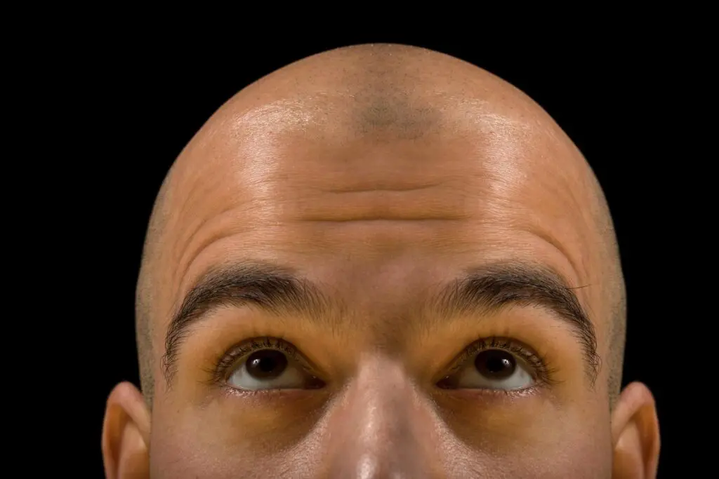 Bald man's head and eyes looking up.